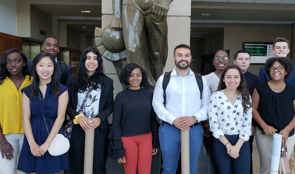 2019 REPID cohort standing in front of statue