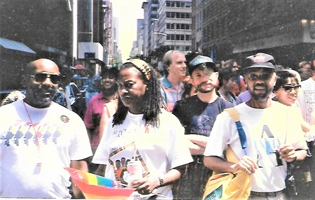 Moore at his first ever PRIDE March in NYC walking in a large group of people.