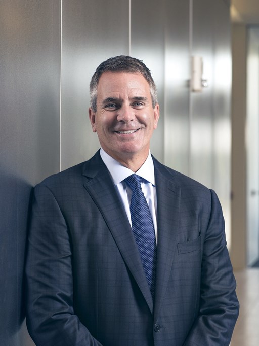 Headshot of Ray Scott standing in front of an office wall.