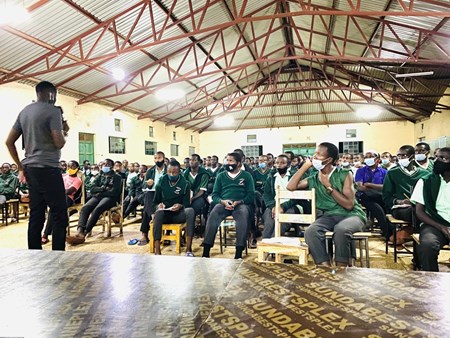 Mithika speaking to a large group of people