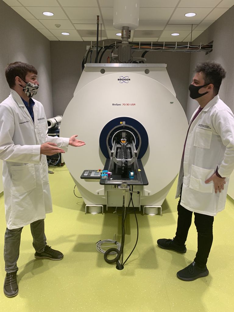 MSU graduate students Alexander Bricco (left, Gilad Lab) and Iliya Miralavykomsari (right, Banzhaf Lab) with an MRI in the background. 