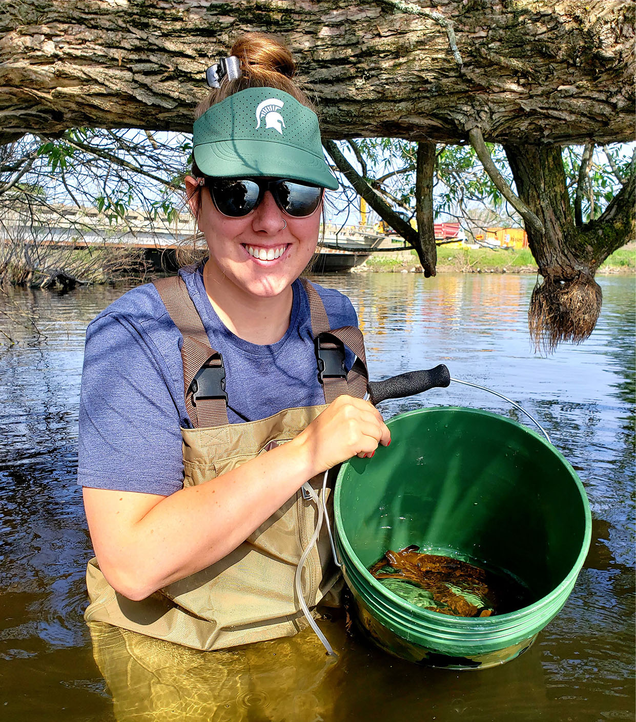 Kandace Griffin holding a bucket of sea lampreys