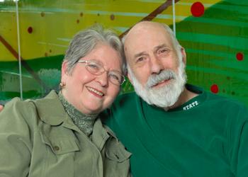 Barbara and Don Sawyer wearing green on a green background. 