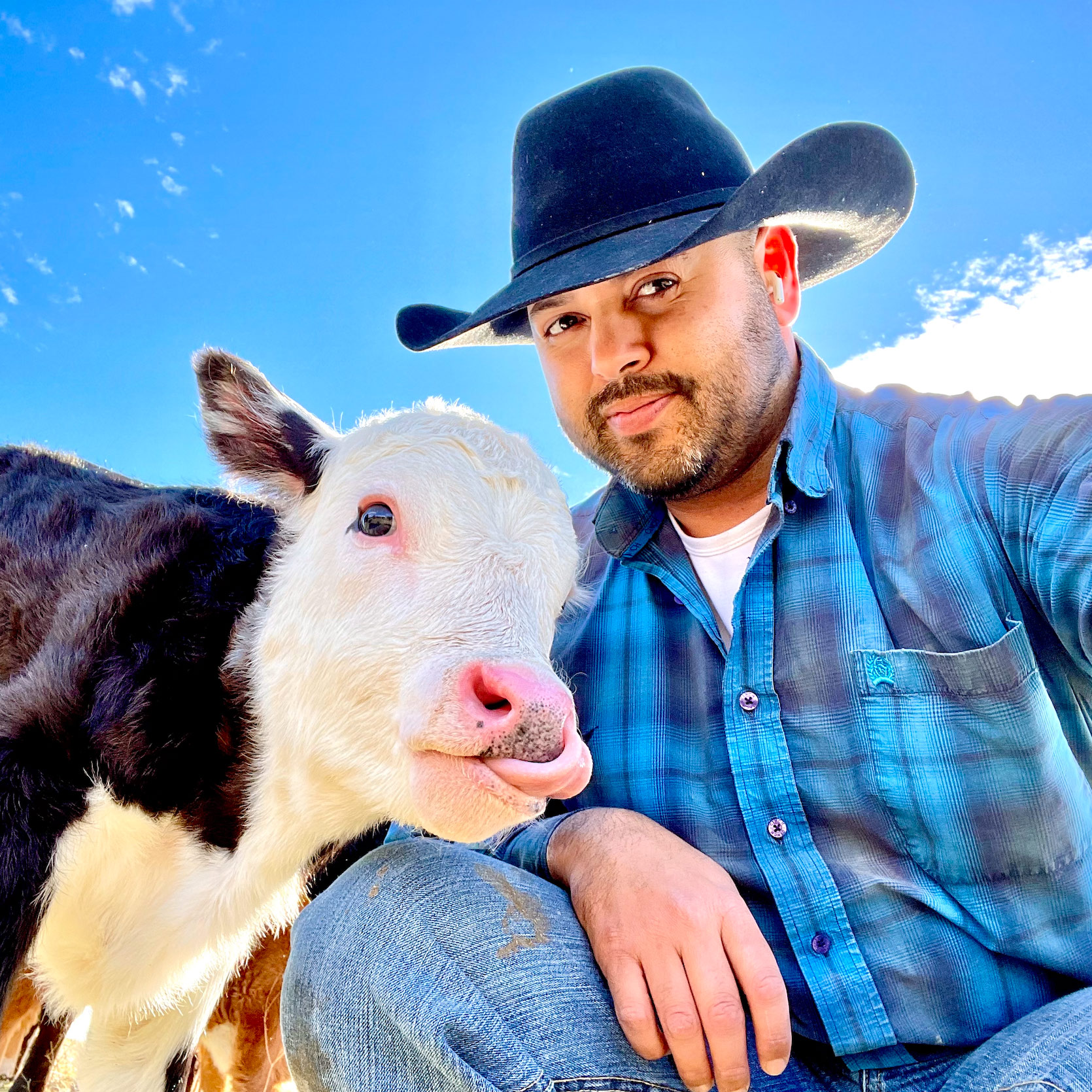 Orlando Ochoa posing for a selfie with a baby cow