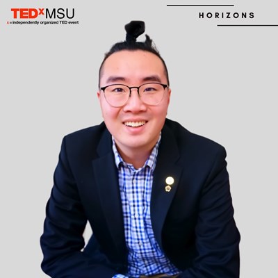 Kyle Chong under a TedxMSU banner
