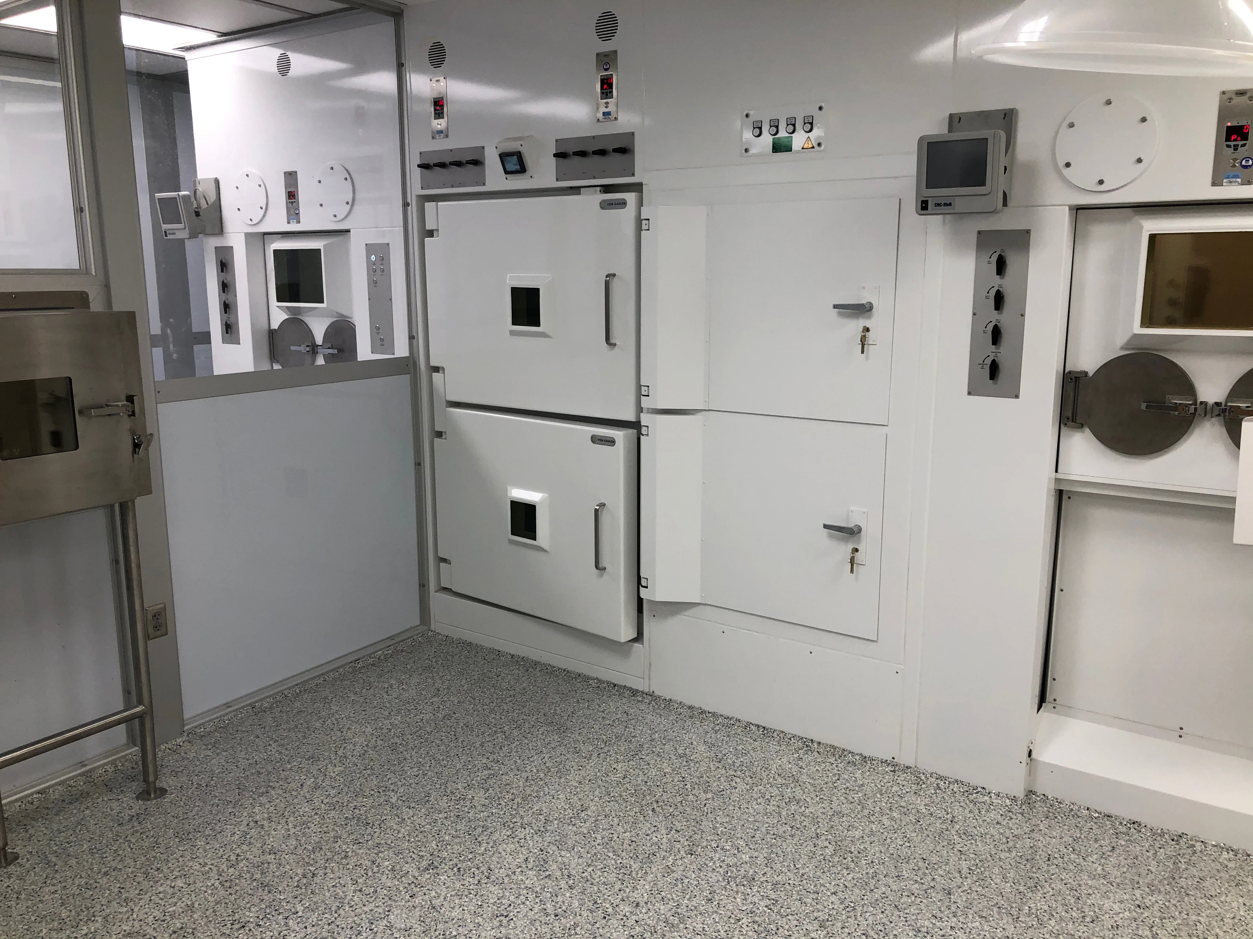 A photograph from inside MSU’s new radiopharmacy shows white cabinets and chambers with screens where researchers will store and work with radioisotopes.