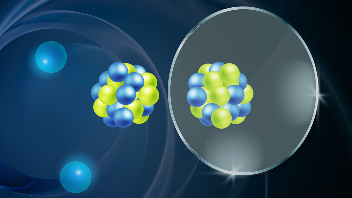 An illustration shows an atom made of green and blue orbs representing protons and neutrons reflected in a mirror, with its green and blue orbs flipped.
