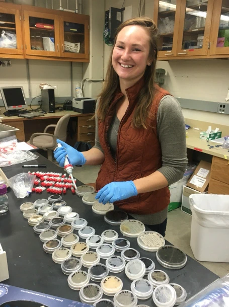 A photo shows Heather Kittredge in lab, holding a pipette near many sample containers.