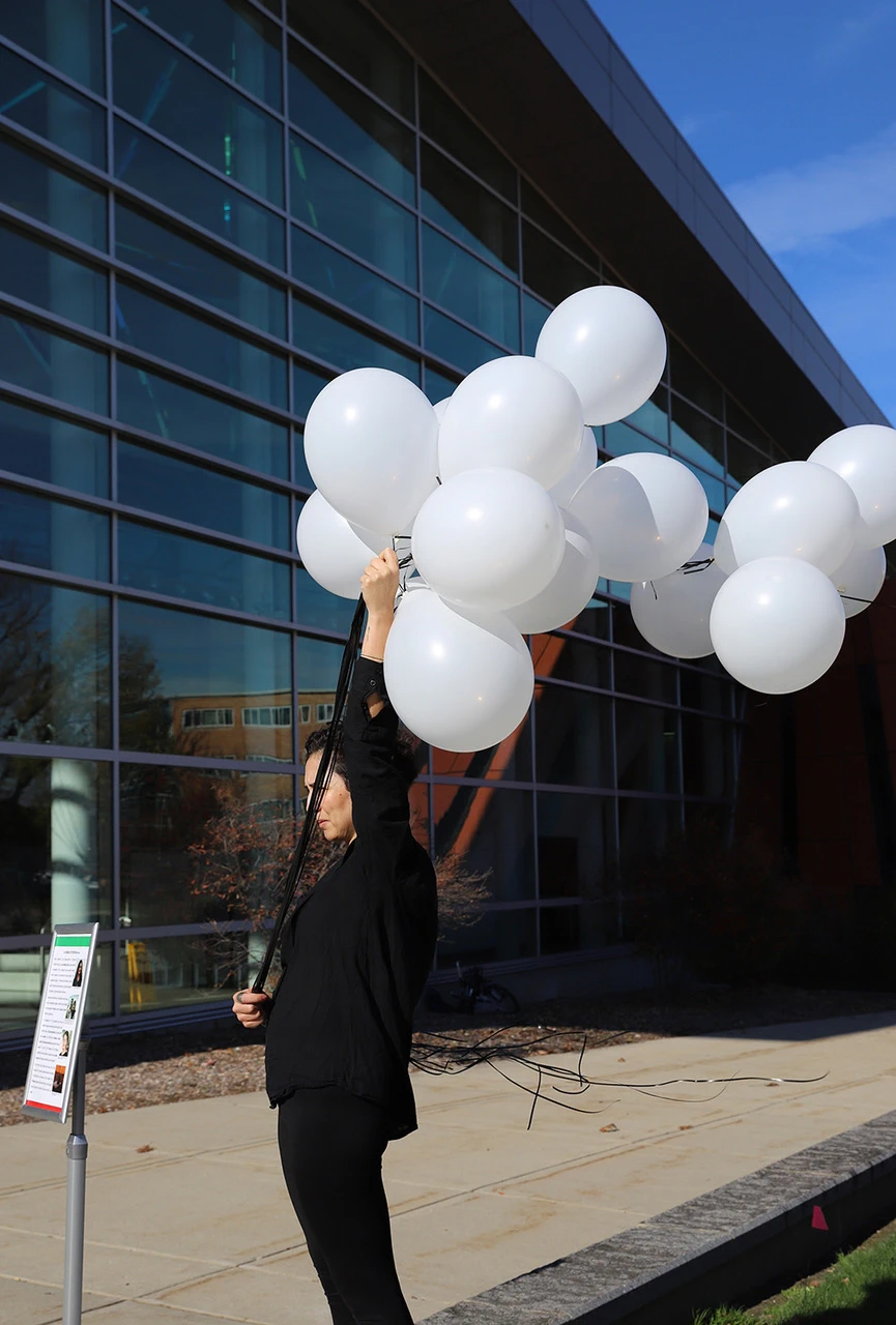 Parisa Ghaderi holds balloons as part of her performance for Iran prisoners and detainees.