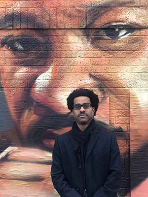 Brian Johnson standing in front of MLK mural