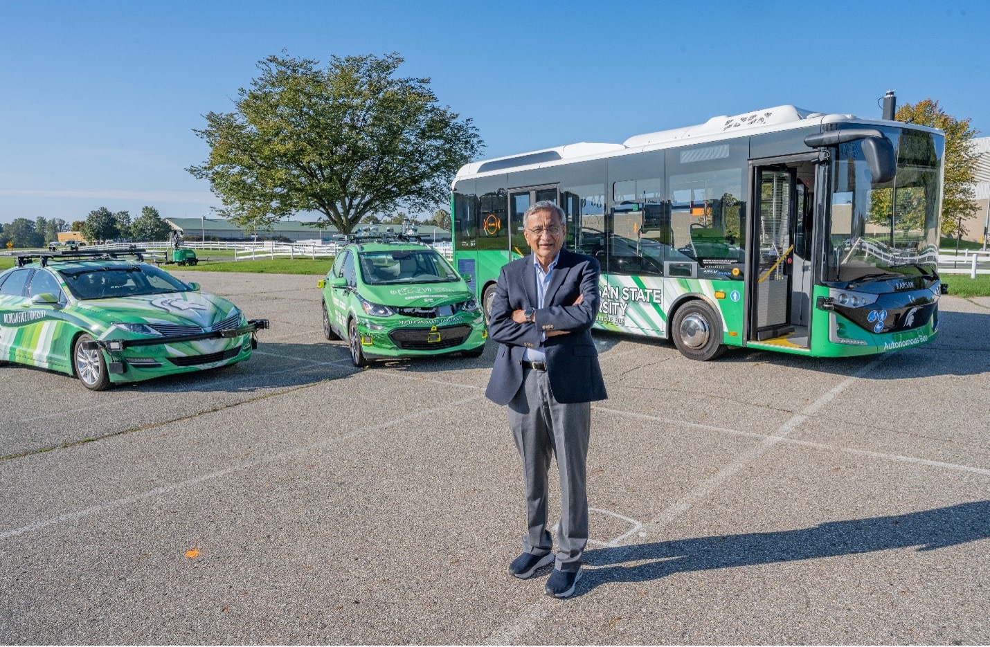 Satish Udpa in front of autonomous vehicles on campus.