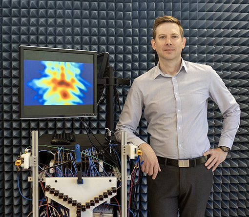 Jeffrey Nanzer stands next to a millimeter-wave radar system designed to locate and image objects using communications signals.