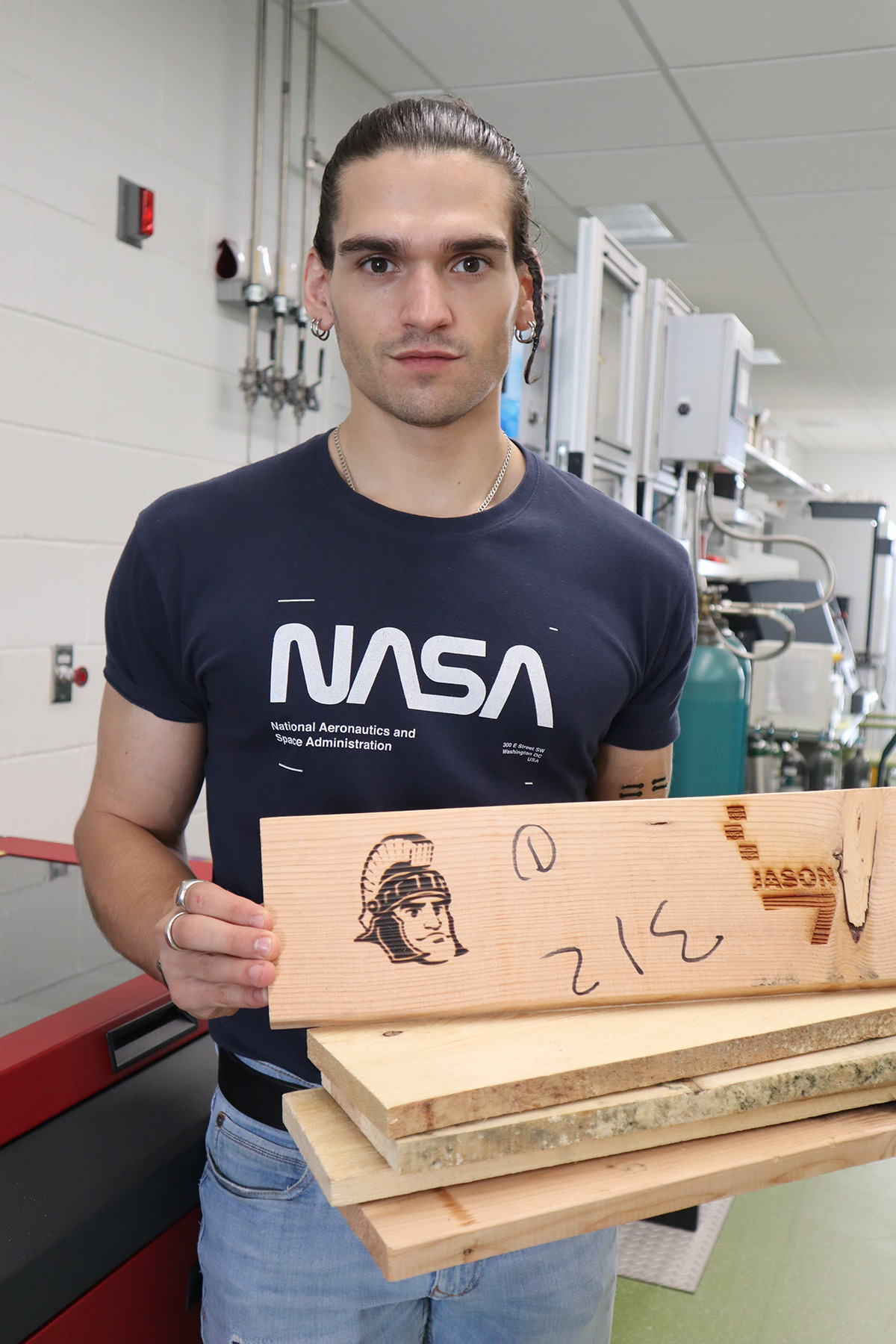 Vittorio Mottini, a biomedical engineering doctoral student in Jinxing Li’s lab at MSU, holds a stack of samples the team is using in their new “living wood” project. The team laser etched an image of Sparty, MSU’s mascot, in the top plank. Credit: Jinxing Li 
