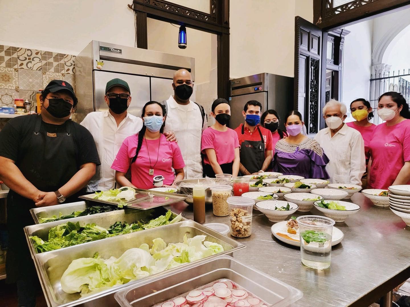 Marlon Lynch standing with students in food prep kitchen.