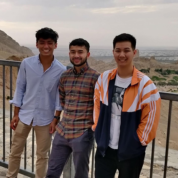Ben Sagritalo, Rafael Paz and David Tran stand in front of the landscape in Al Ain.