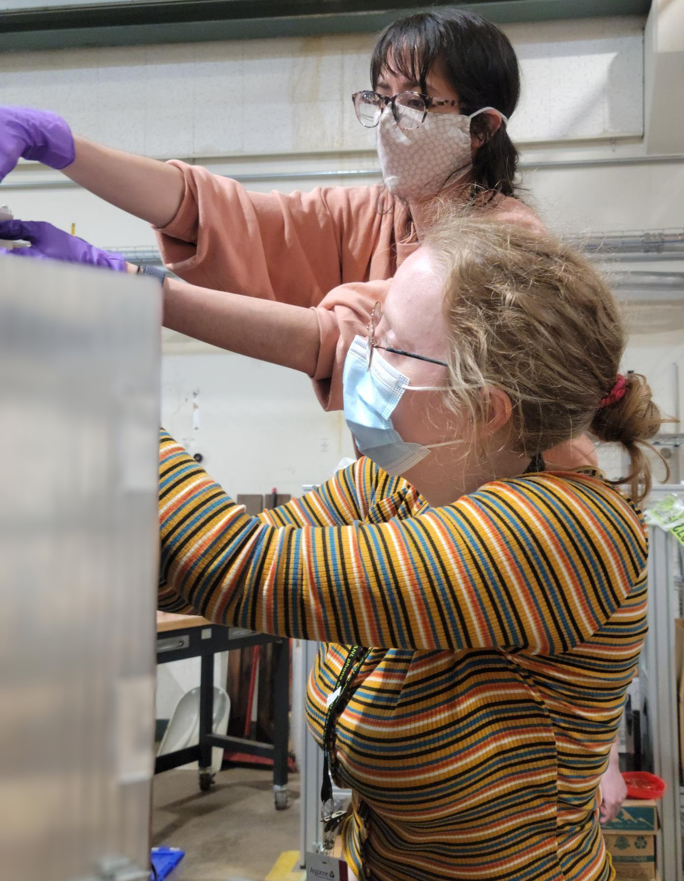 Hannah Berg (front) and lab mate Caley Harris (back) work on detector instrument at Argonne National Laboratory.
