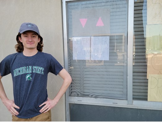 Ryan Peters standing next to a window posing.