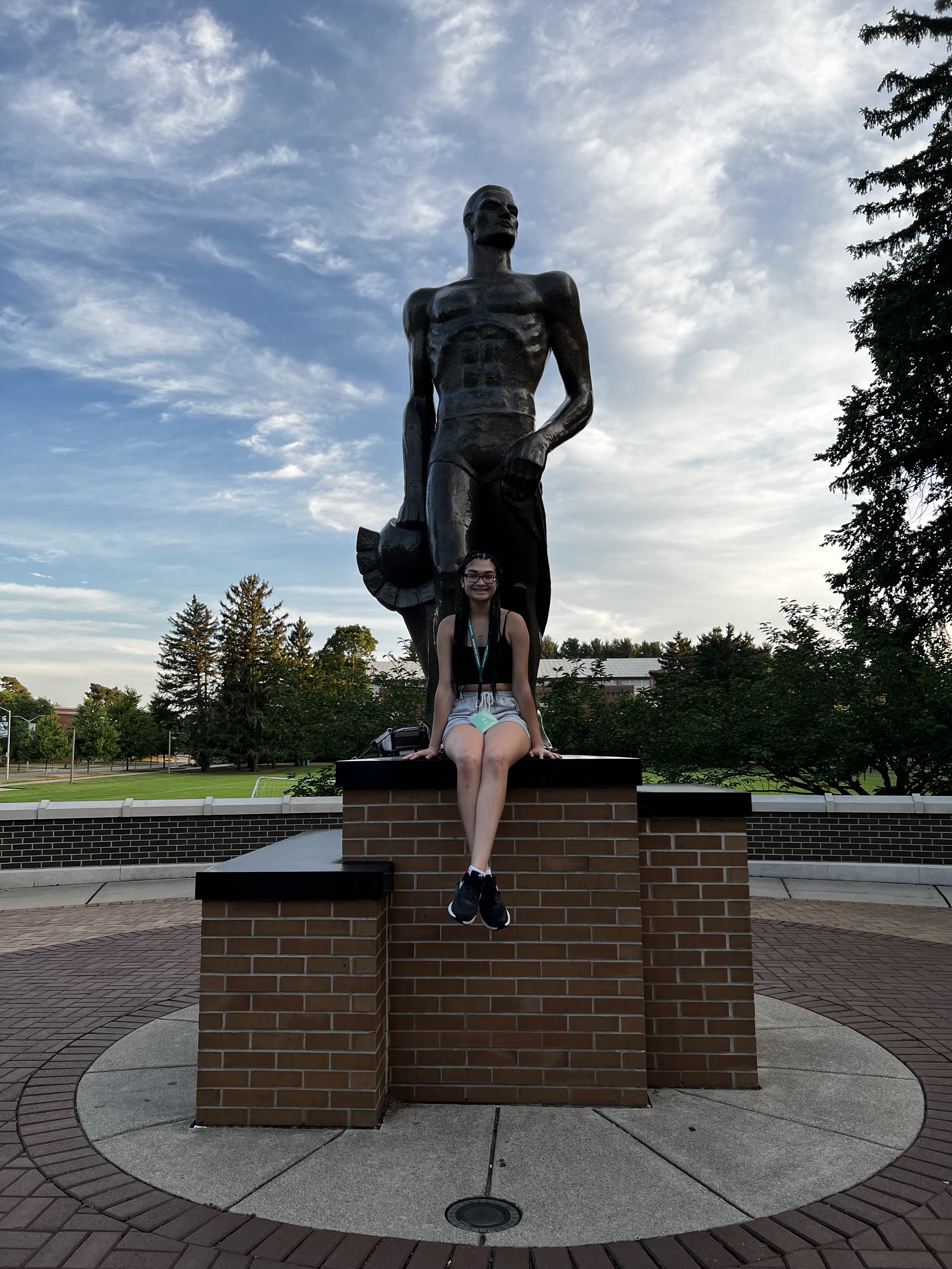 Mikia Lawrence sitting at the foot of the Spartan statue.