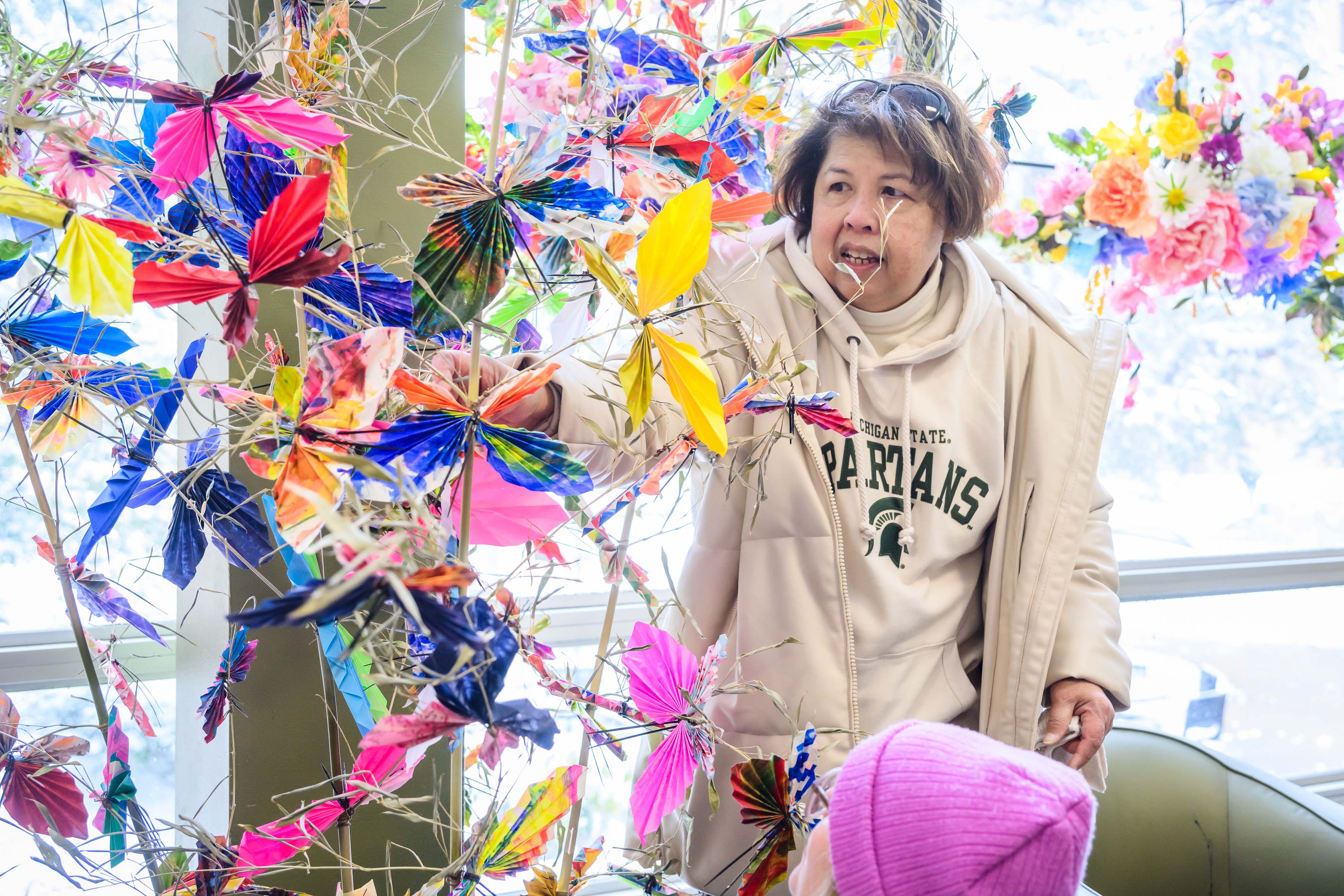 Artist-in-resident Zahrah Resh adds the finishing touches to the butterfly garden installation in the International Center's lobby.