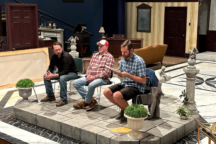 Levi Galloway, D.J. Selmeyer and Marc White sit on chairs on a theater set.