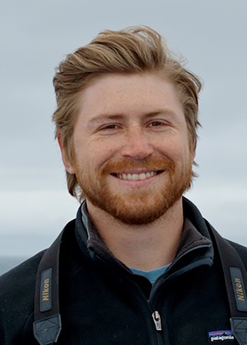 Casey Younglesh, a MSU postdoctoral fellow--a man with strawberry blonde hair and beard, smiles