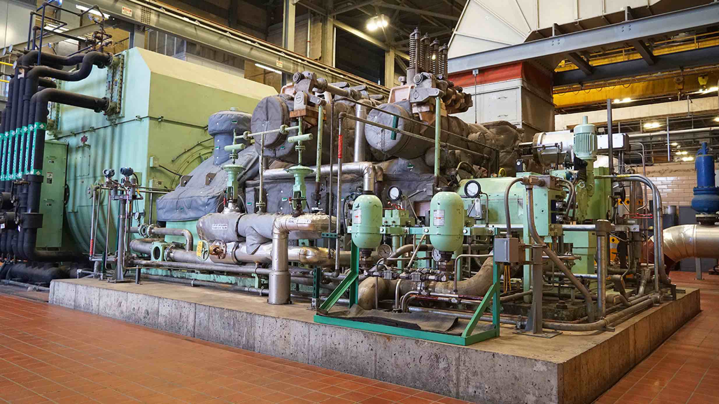 A large piece of equipment with multiple pipes and gauges sits on a cement pad at MSU’s T.B. Simon Power Plant. 