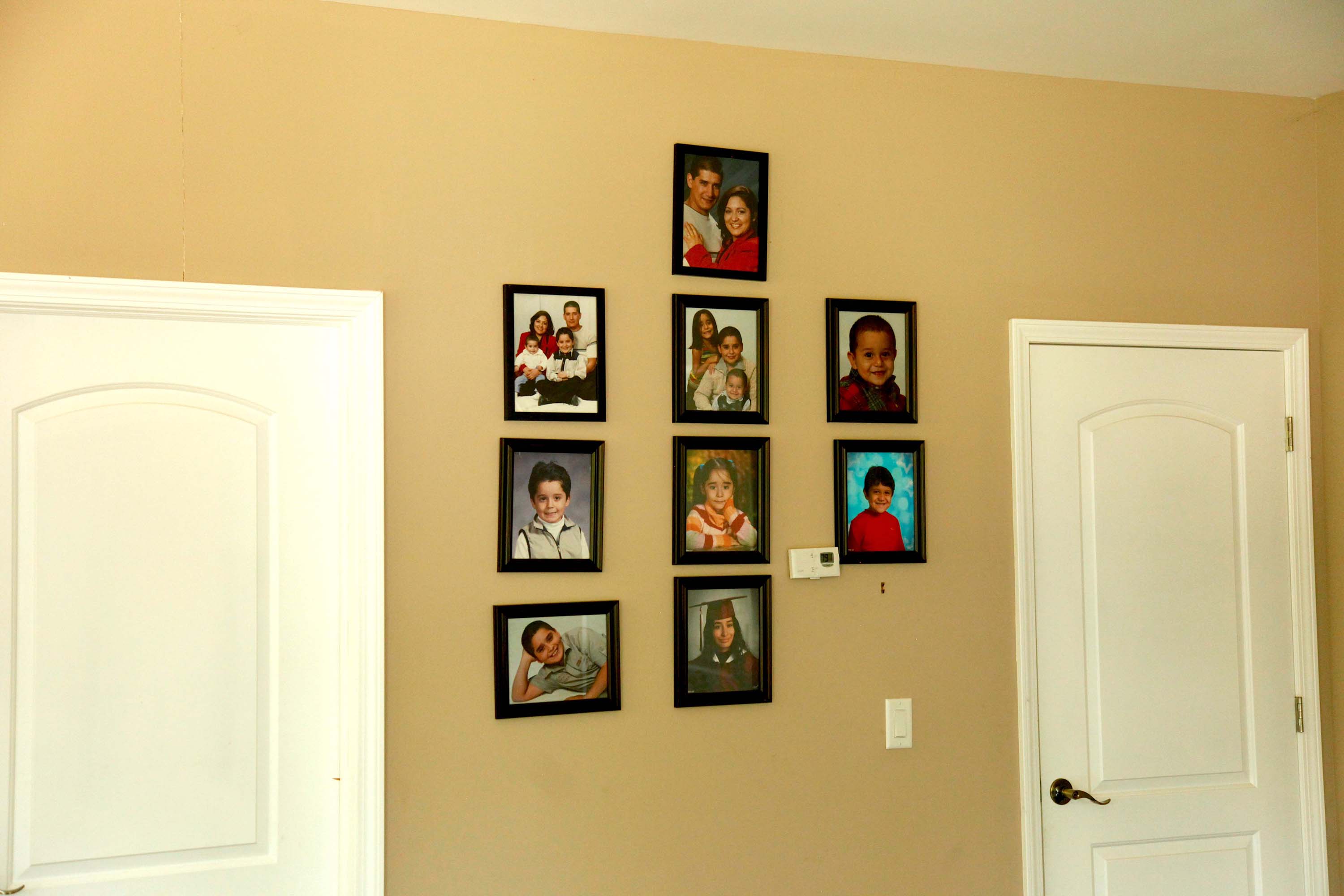 Framed photos adorn a mustard-colored wall, displaying the Avalos family through the years.