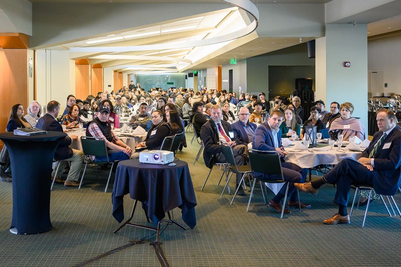 Audience seated around tables at the celebration