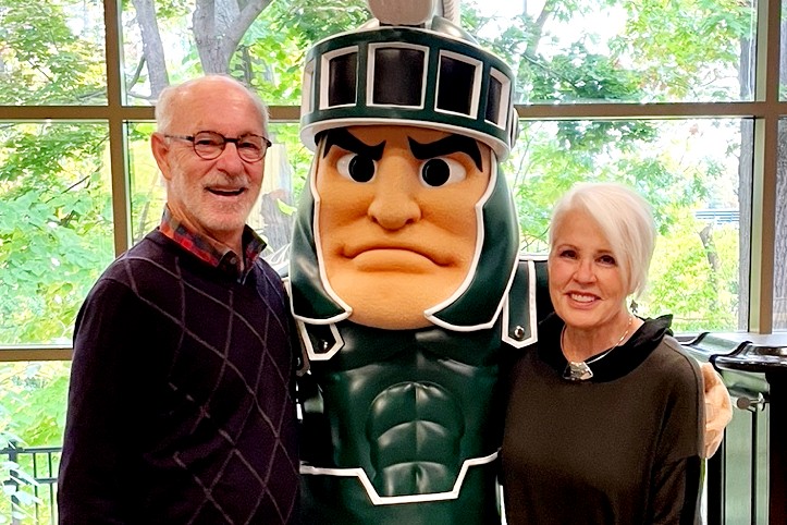 John and Alaine Weiss and Sparty pose for a photo.