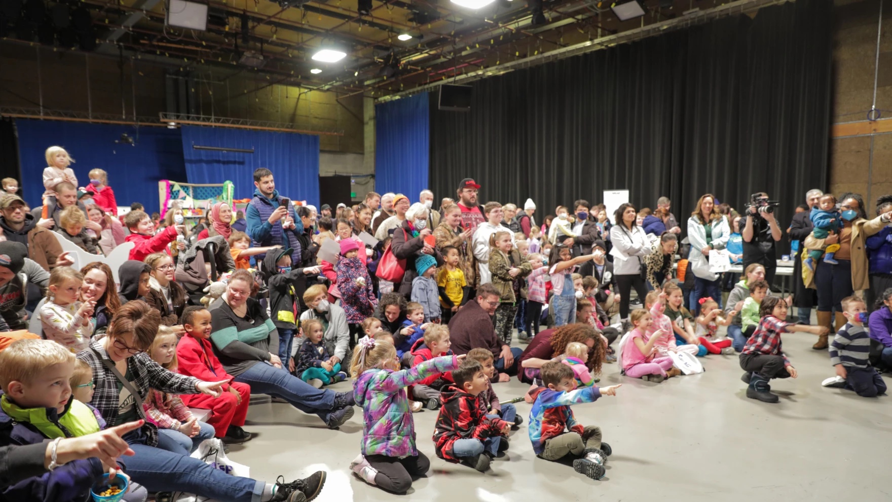 Children and their families gather in WKAR Studio A to partake in the interactive Curious Crew activities on stage.