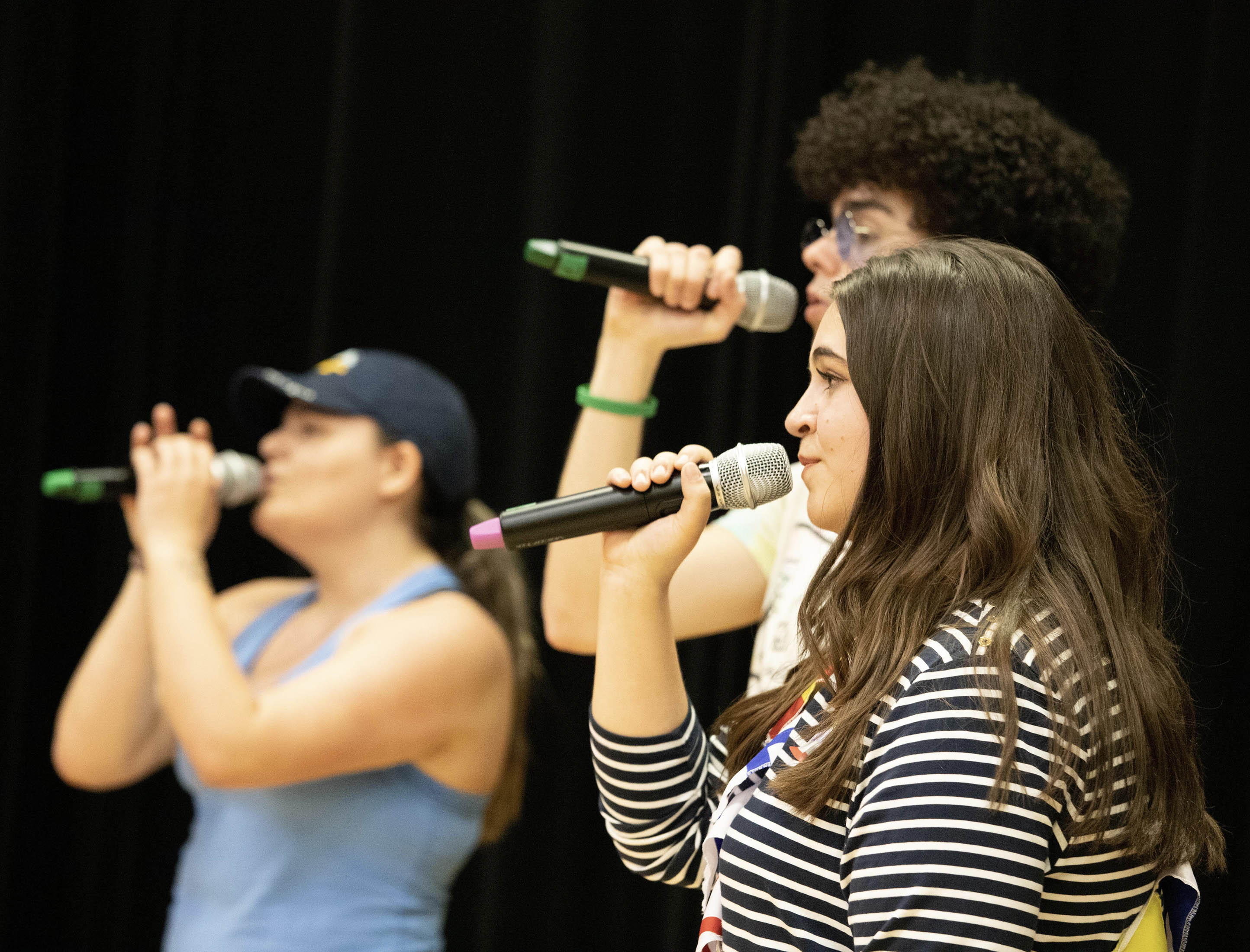 Maren Case singing with microphone and other students
