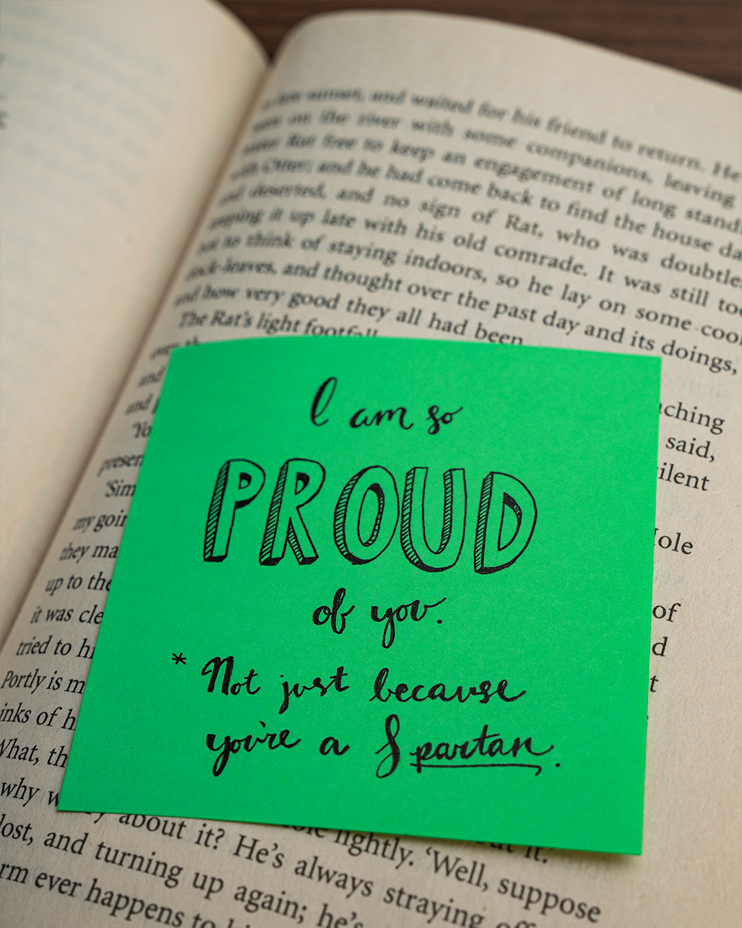 Sticky note on top of book reading I am so proud of you. *Not just because you're a Spartan