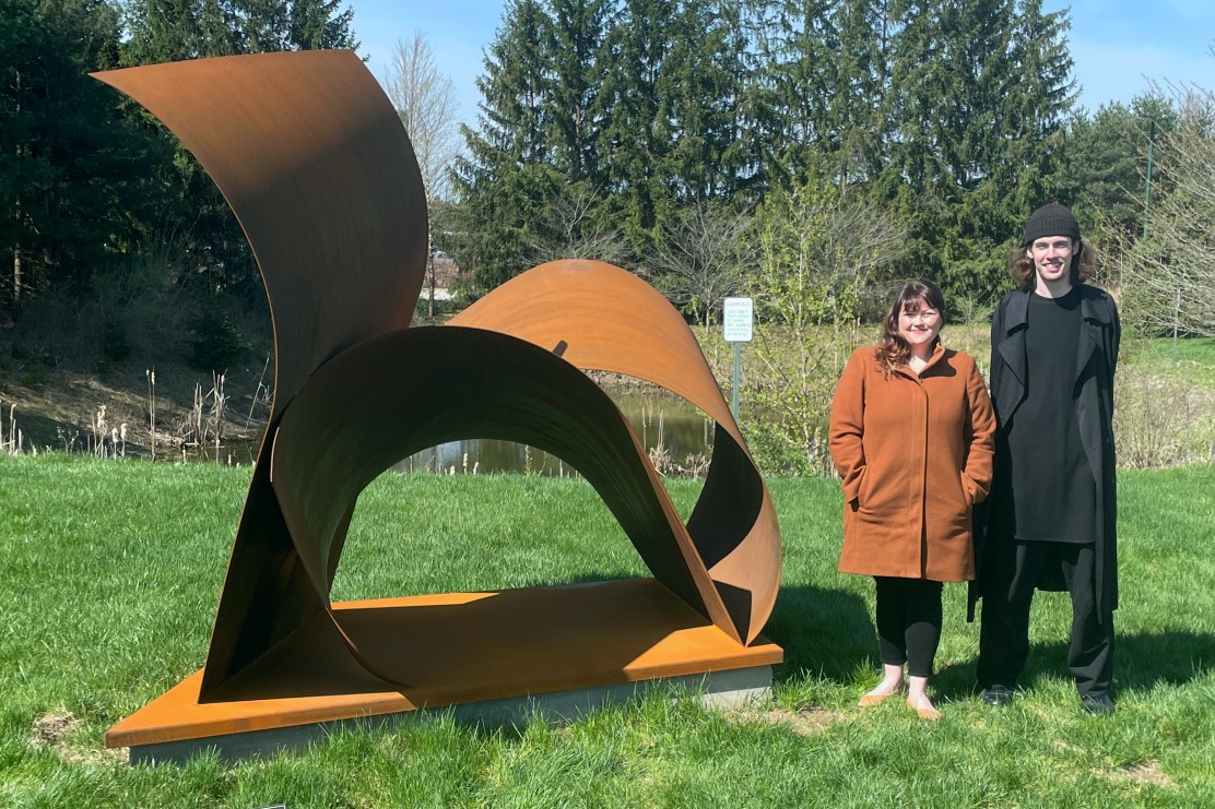 Jacquelynn Sullivan Gould and Alex Vonhof with their “Us” sculpture at the MSUFCU headquarters in East Lansing.