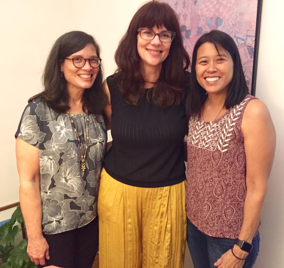 Three diverse women stand for a photo