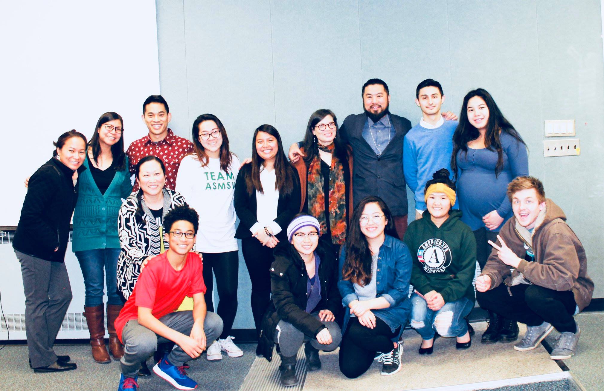 Participants stand for a picture with the speaker following an event