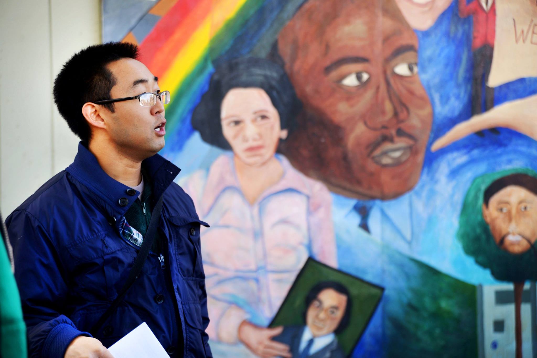 Soh Suzuki speaks to students off camera in front of Vincent Chin mural in Detroit