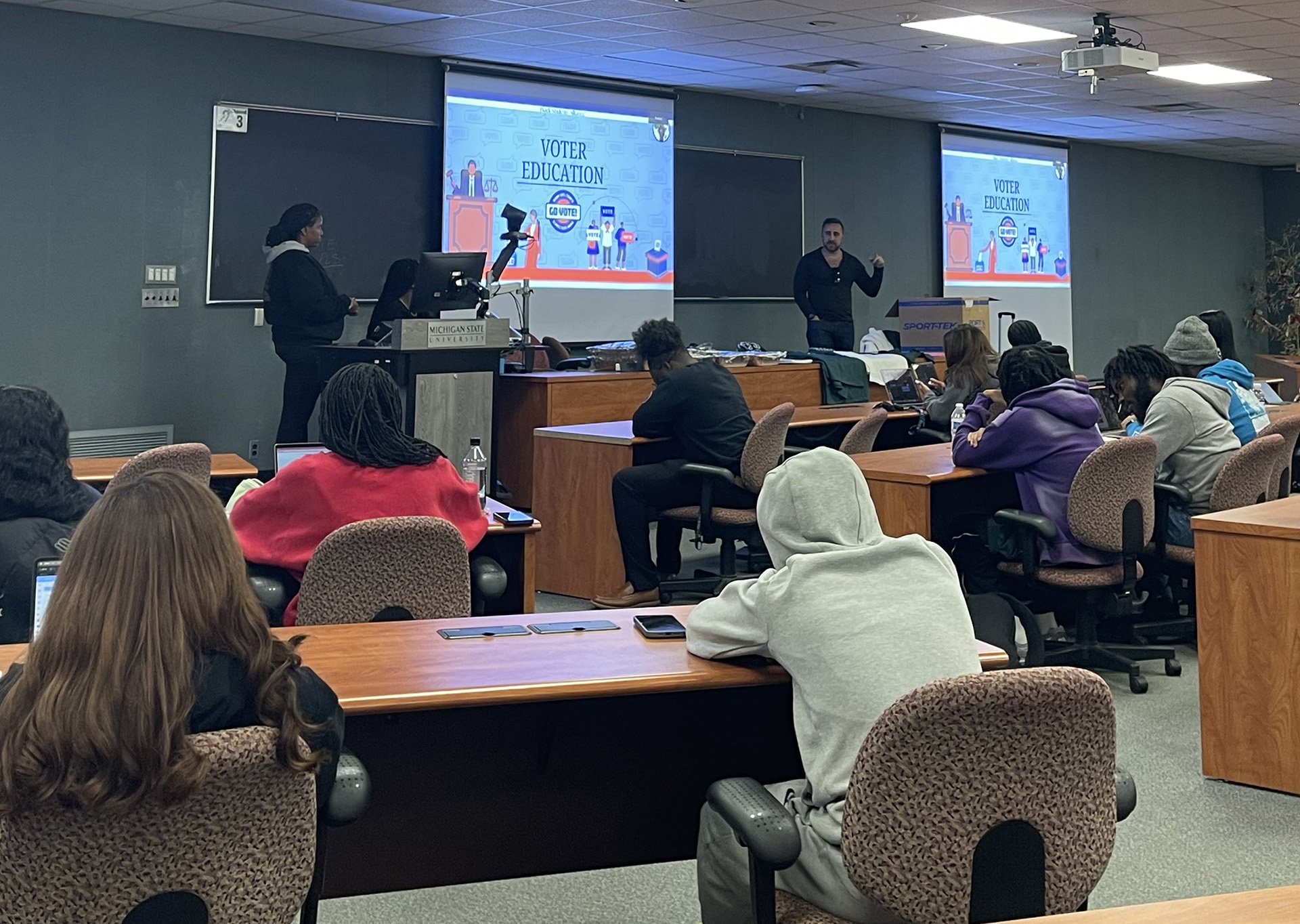 classroom with students facing forward with the presenter speaking