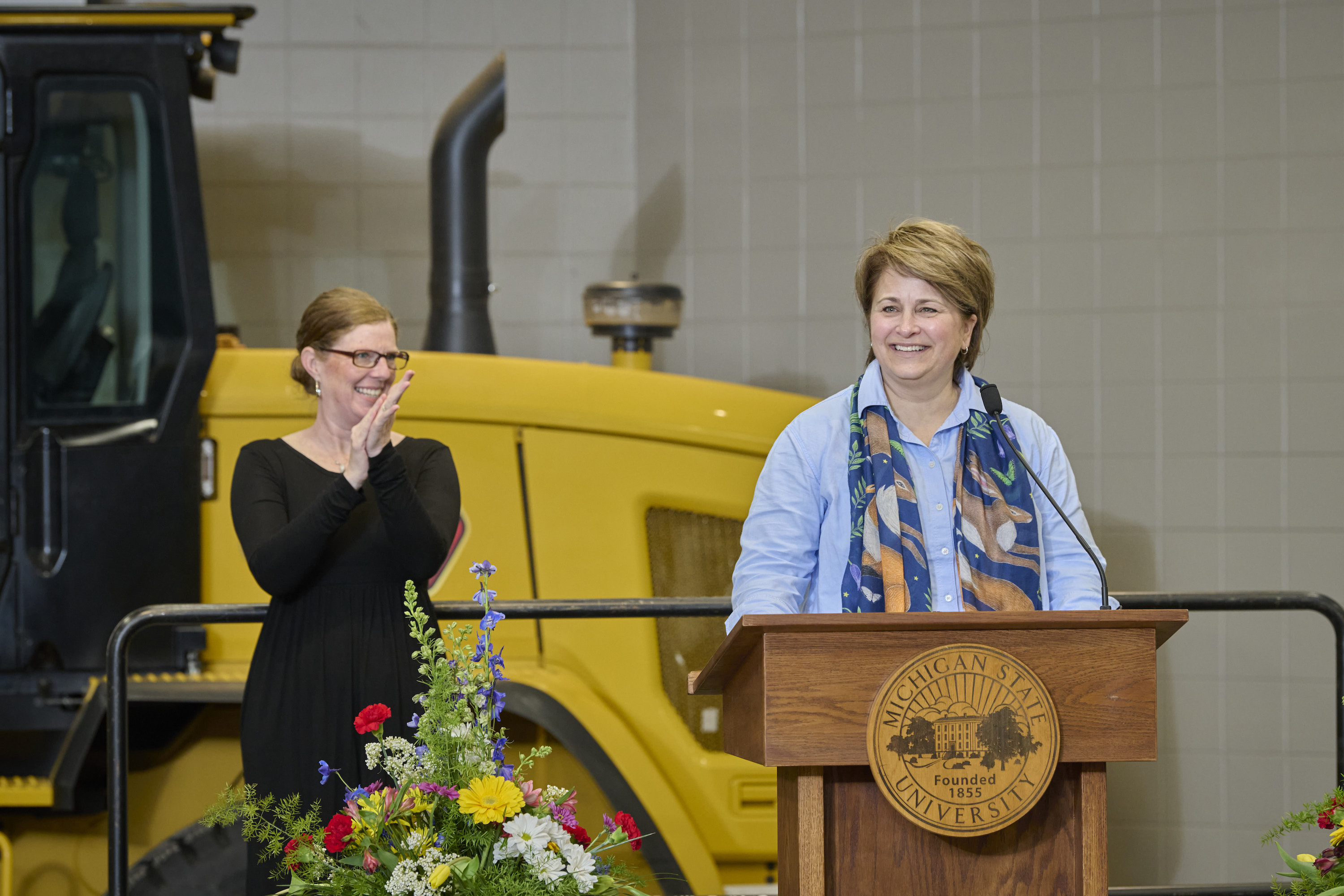 Kelly Millenbah, dean of the College of Agriculture and Natural Resources speaks at a podium with an American Sign Language interpreter standing in the background.