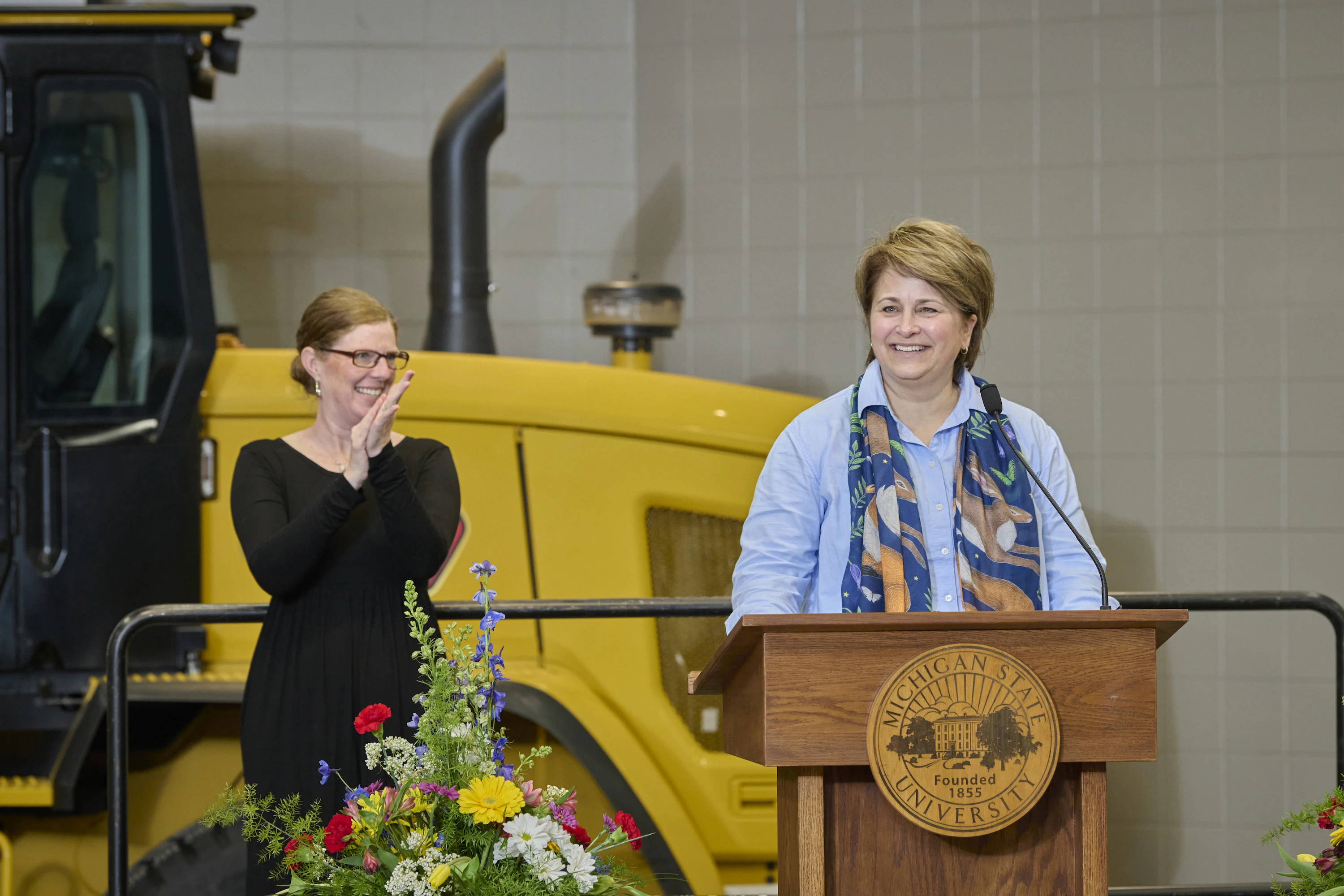 Kelly Millenbah, dean of the College of Agriculture and Natural Resources speaks at a podium with an American Sign Language interpreter standing in the background.