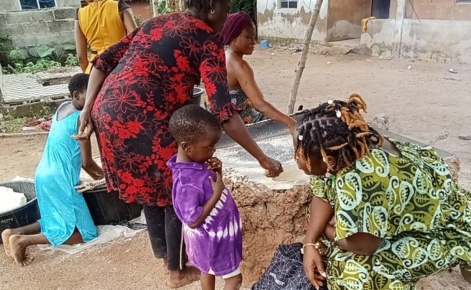 Alábedé, pictured on the right, communicates with child in the village