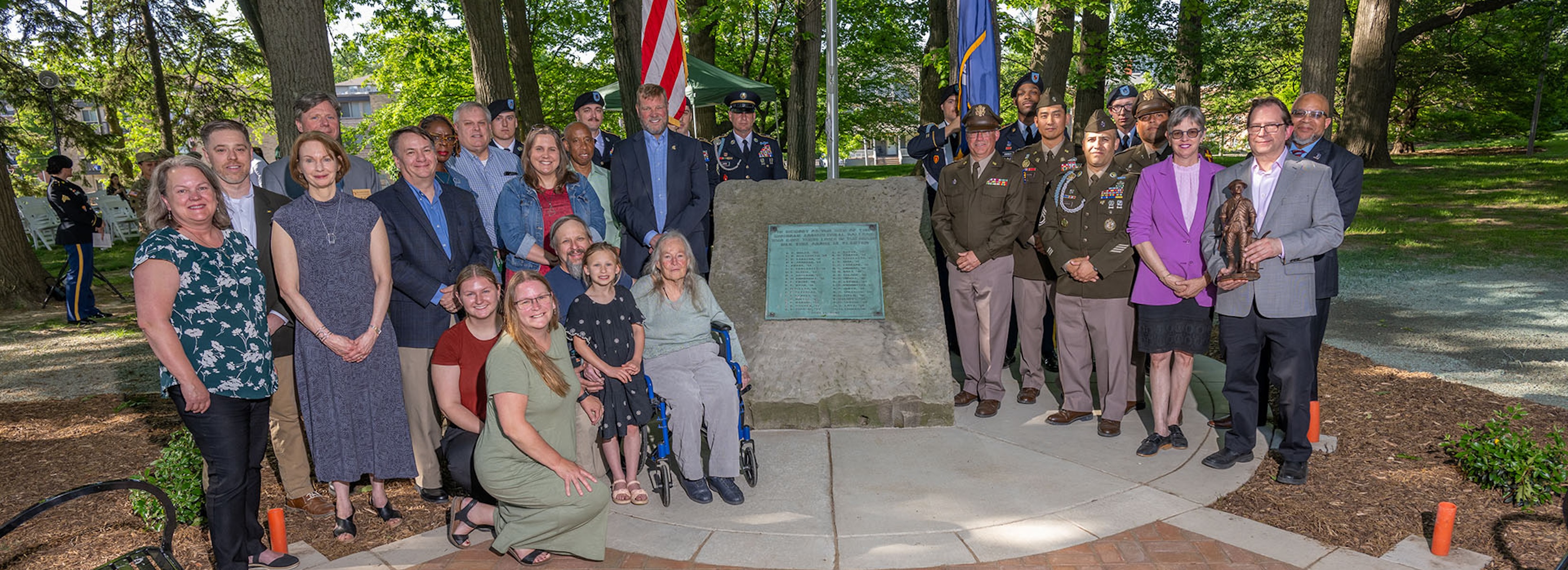 Group photo around the memorial plaque with Michigan State University leaders, staff, community members and Michigan Veterans Affairs staff