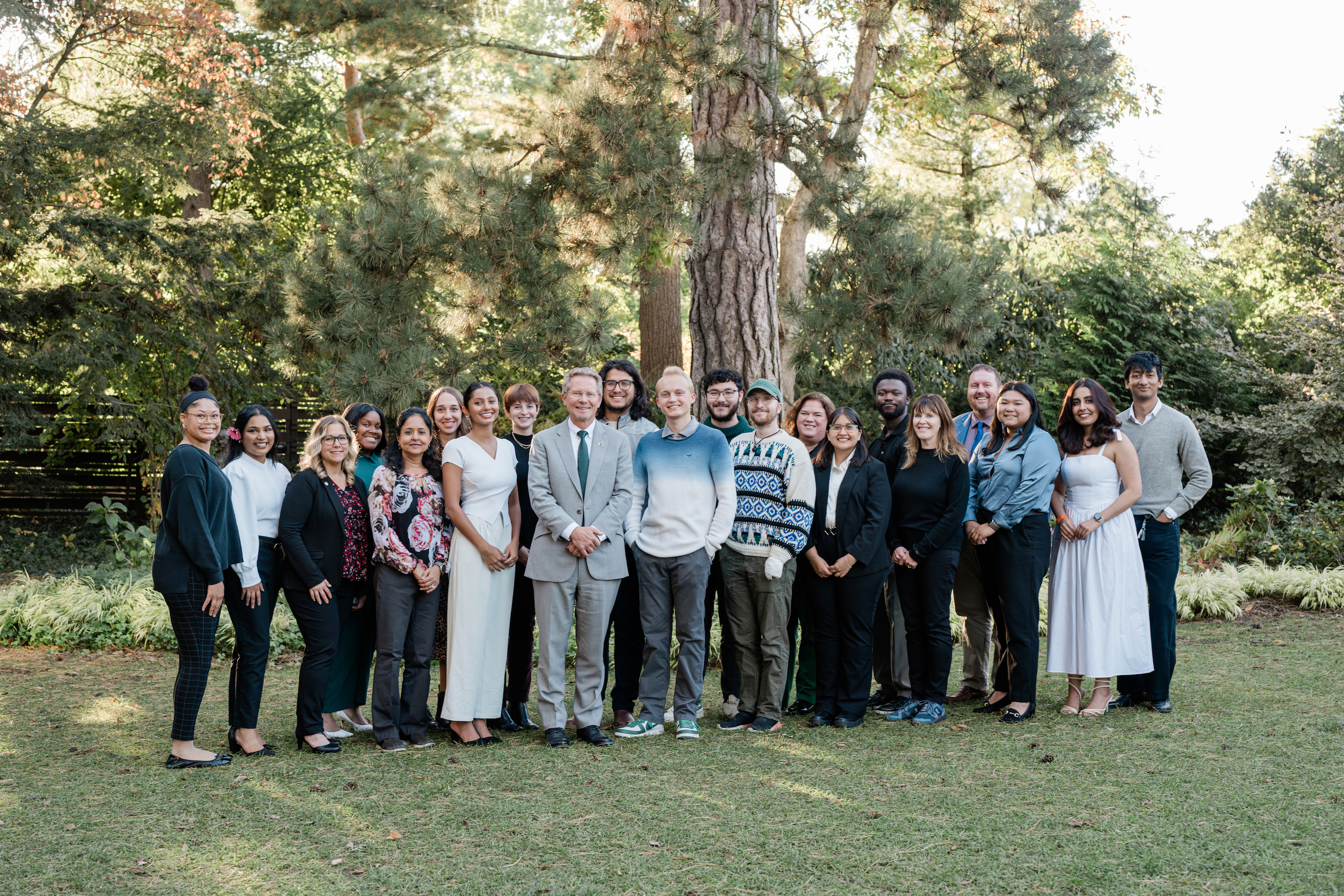 Homecoming court members, along with their nominators, pose in a yard with President Kevin Guskiewicz.