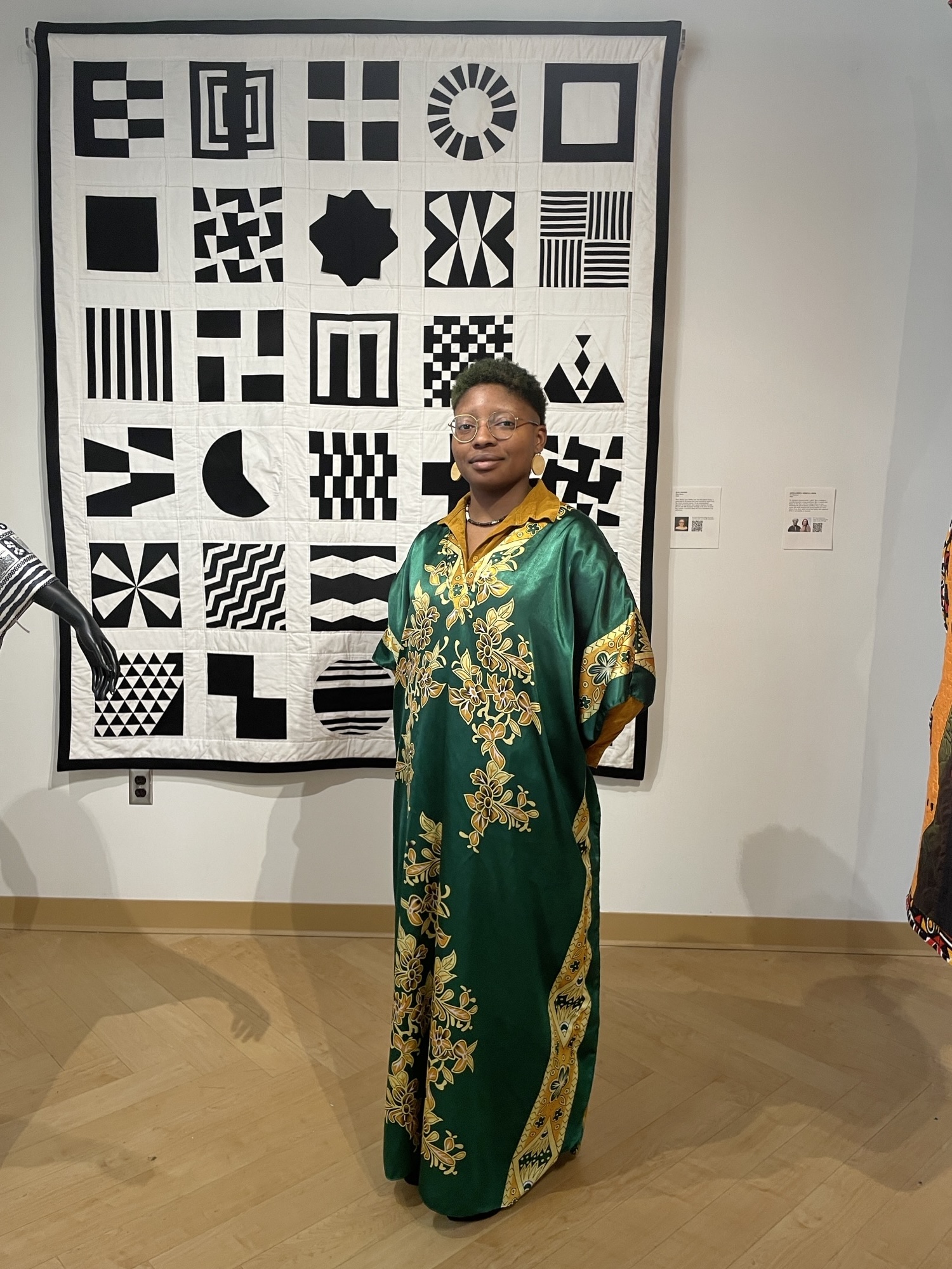Morgan Hill poses with a quilt on display in the background