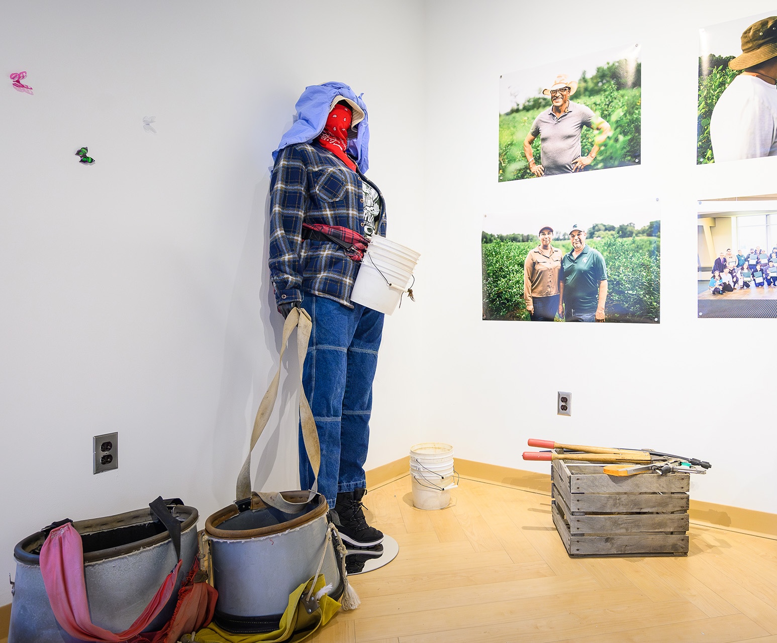 a woman mannequin is dressed in protective clothing with apple picking buckets and sheers below