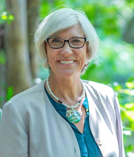 Portrait of Joan Rose, a distinguished water research expert at MSU, smiling in a natural outdoor setting, reflecting her commitment to understanding and solving freshwater challenges within the context of climate and environmental science.