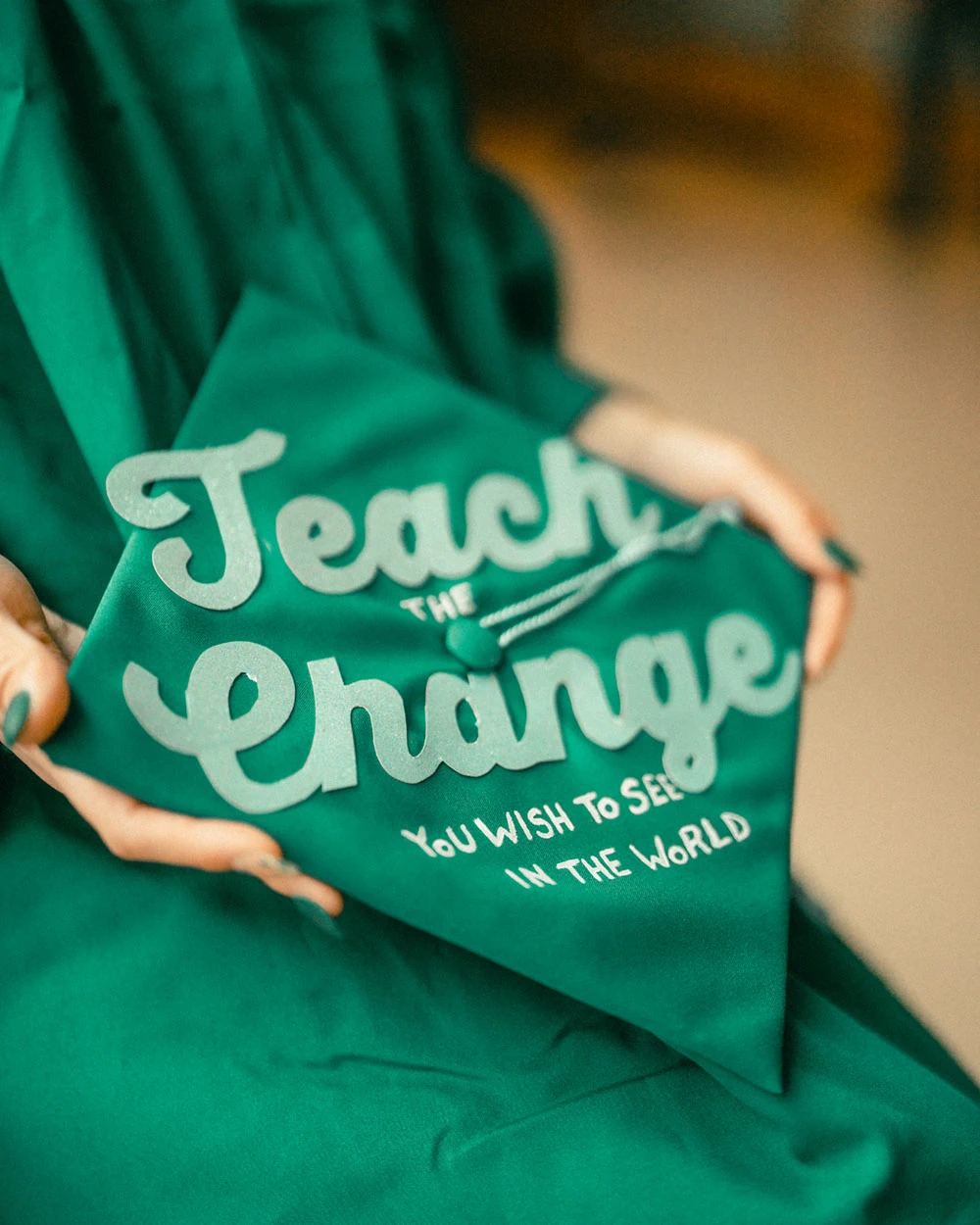 Graduation cap decorated with teach the change you want to see in the world