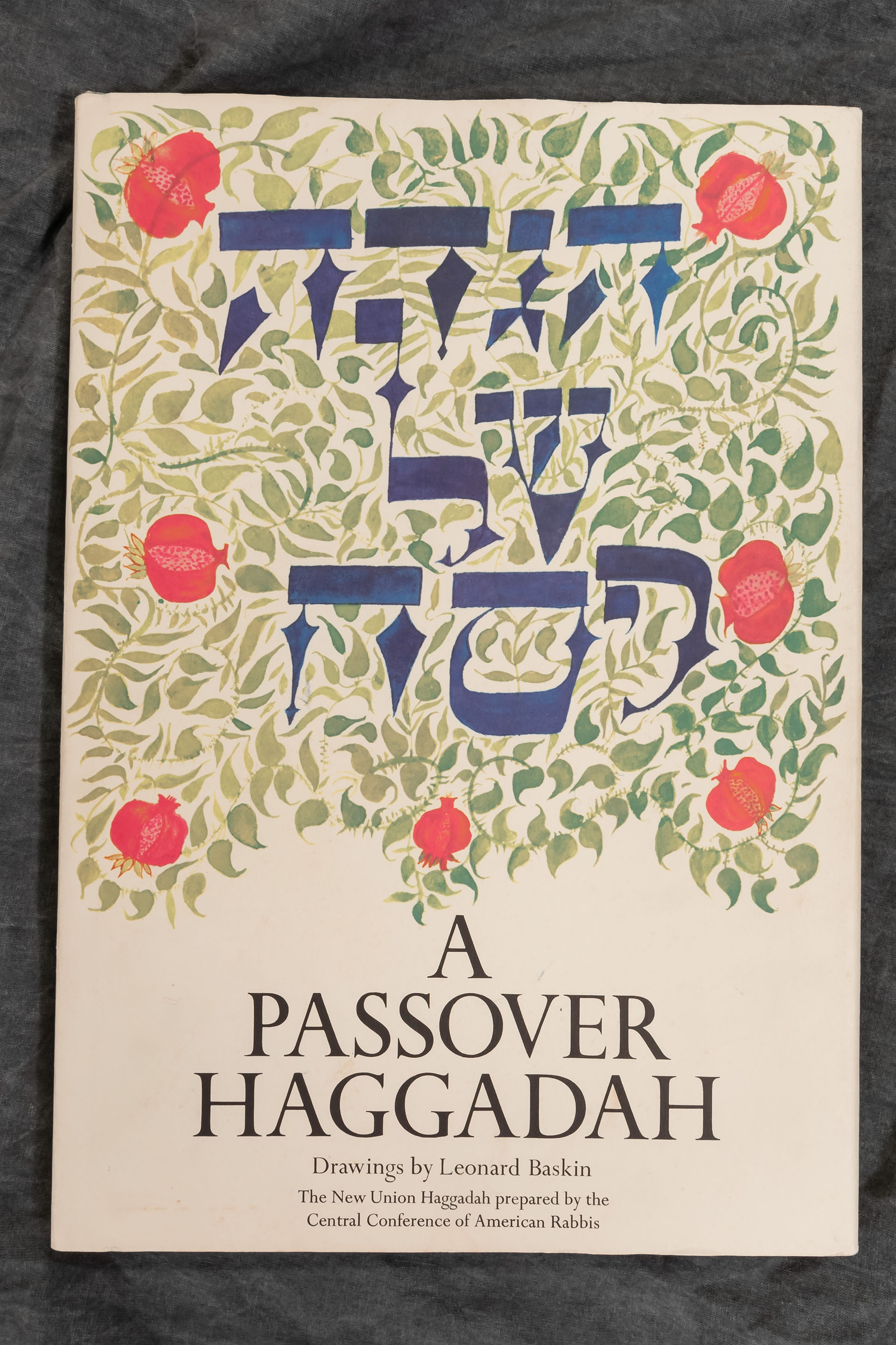 Book cover of a Passover Haggadah with green vines and red flowers
