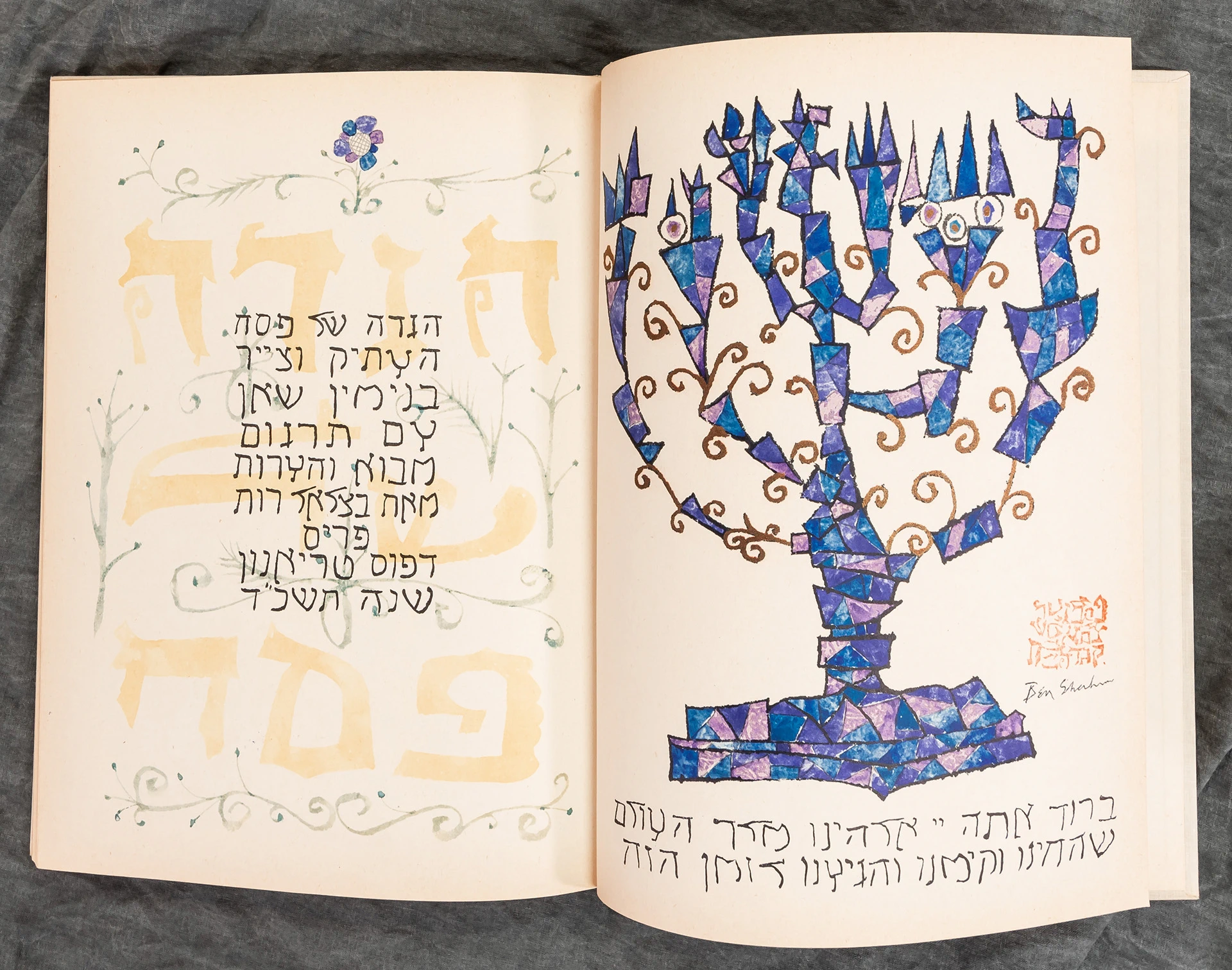 Haggadah book open to a page with text and a menorah candle drawing