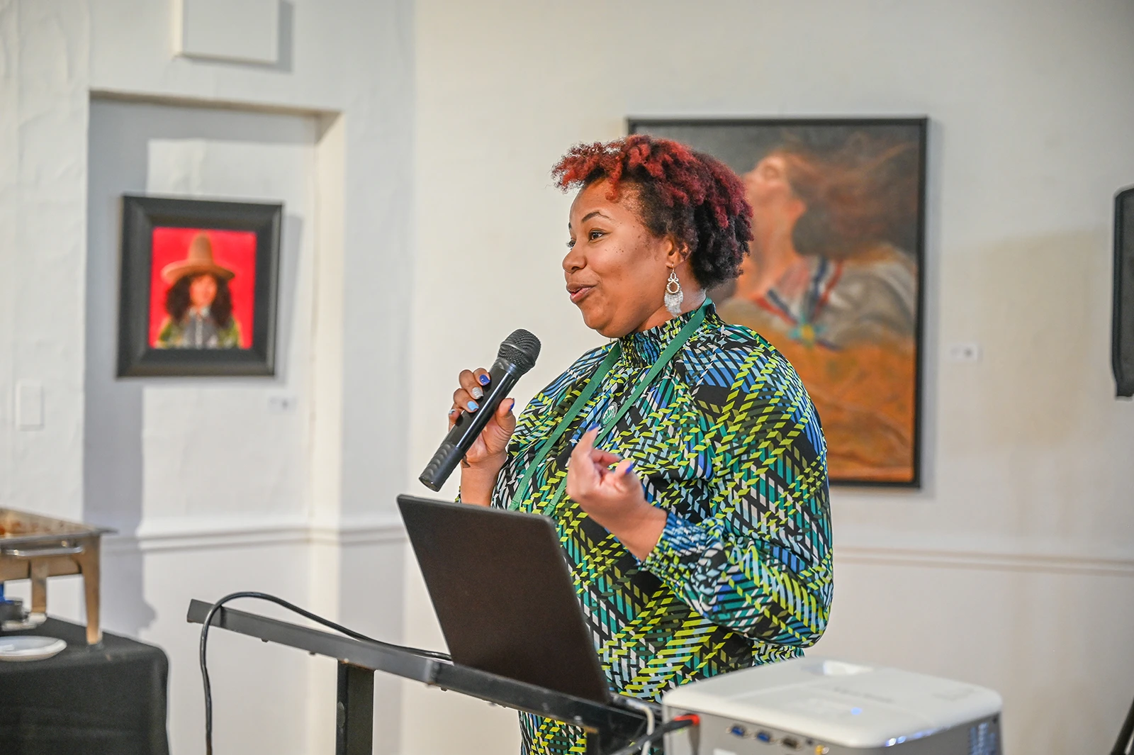 A woman holding a microphone and speaking at a podium.