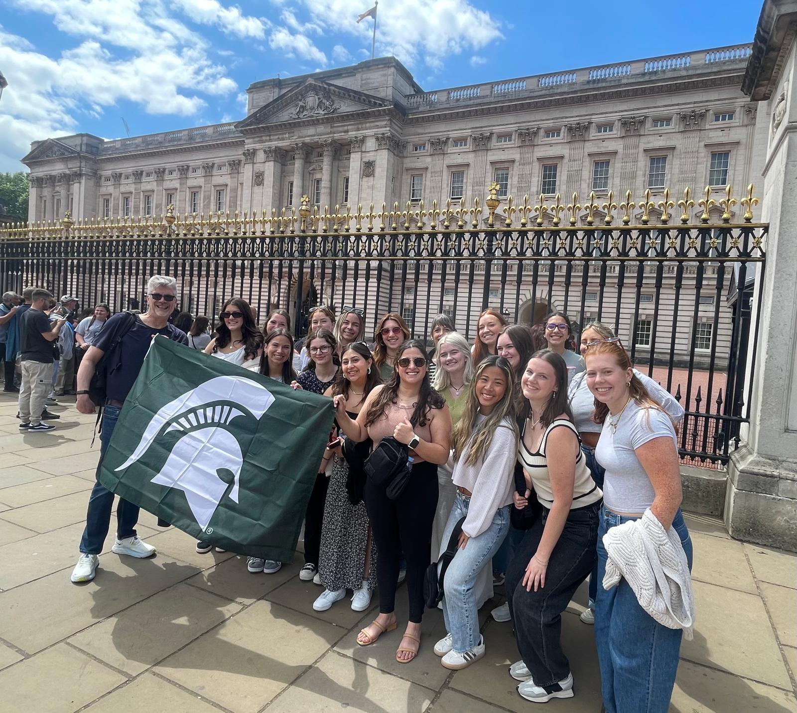 MSU students holding a Spartan flag in London during a study abroad trip.